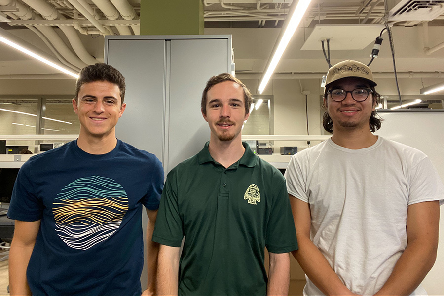 Three men standing side by side in a modern lab environment